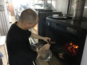 Cocinero de abrasador Grana cocinando en horno de brasa ecologica 